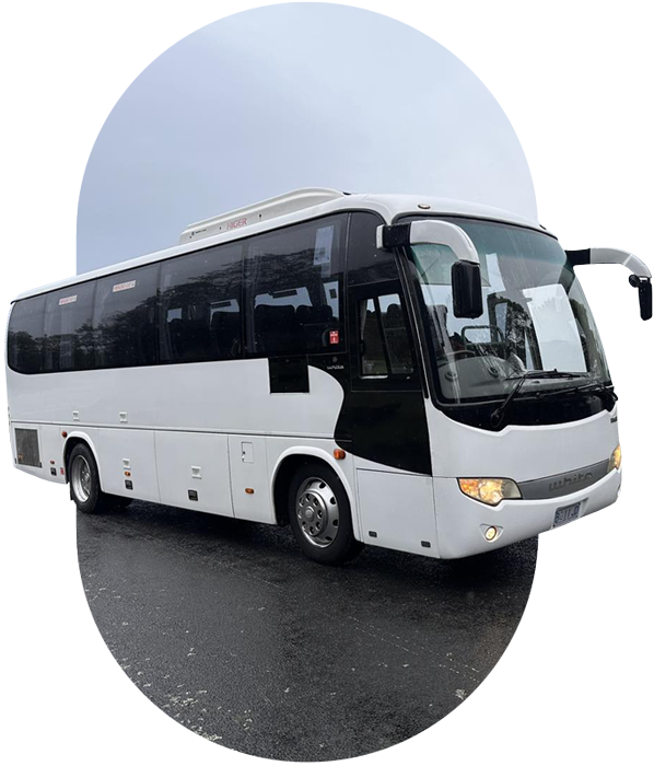 process White coach with its headlights on, parked on a wet road, in an oval frame